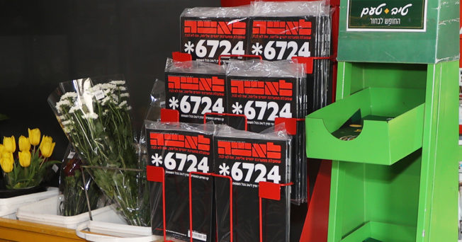 Magazines on a sales rack in Israel show the hotline number 6724 in large type